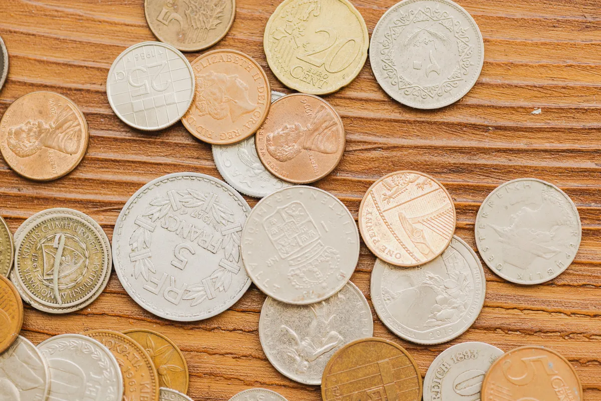A diverse collection of various international coins showing different national emblems and unique currency designs.