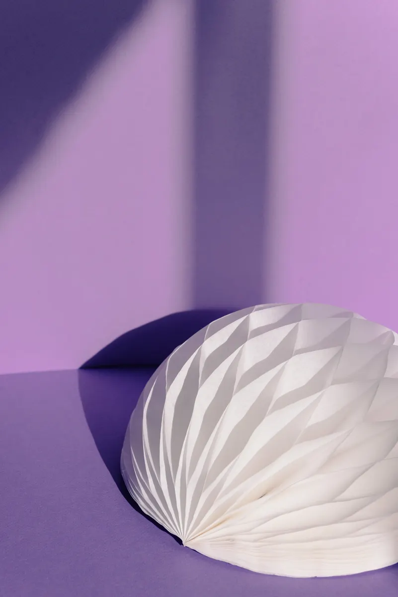 An intricate architectural paper model demonstrating structural cuts and folds resembling a real building.