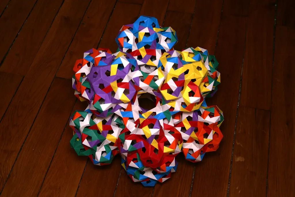 A close-up of a complex modular origami piece featuring a tight and recessed closed sink fold.