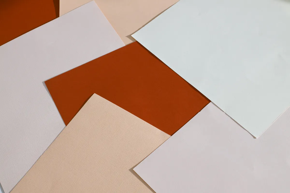 A side-by-side comparison of smooth kami paper, textured washi paper, and shiny metallic foil sheets.