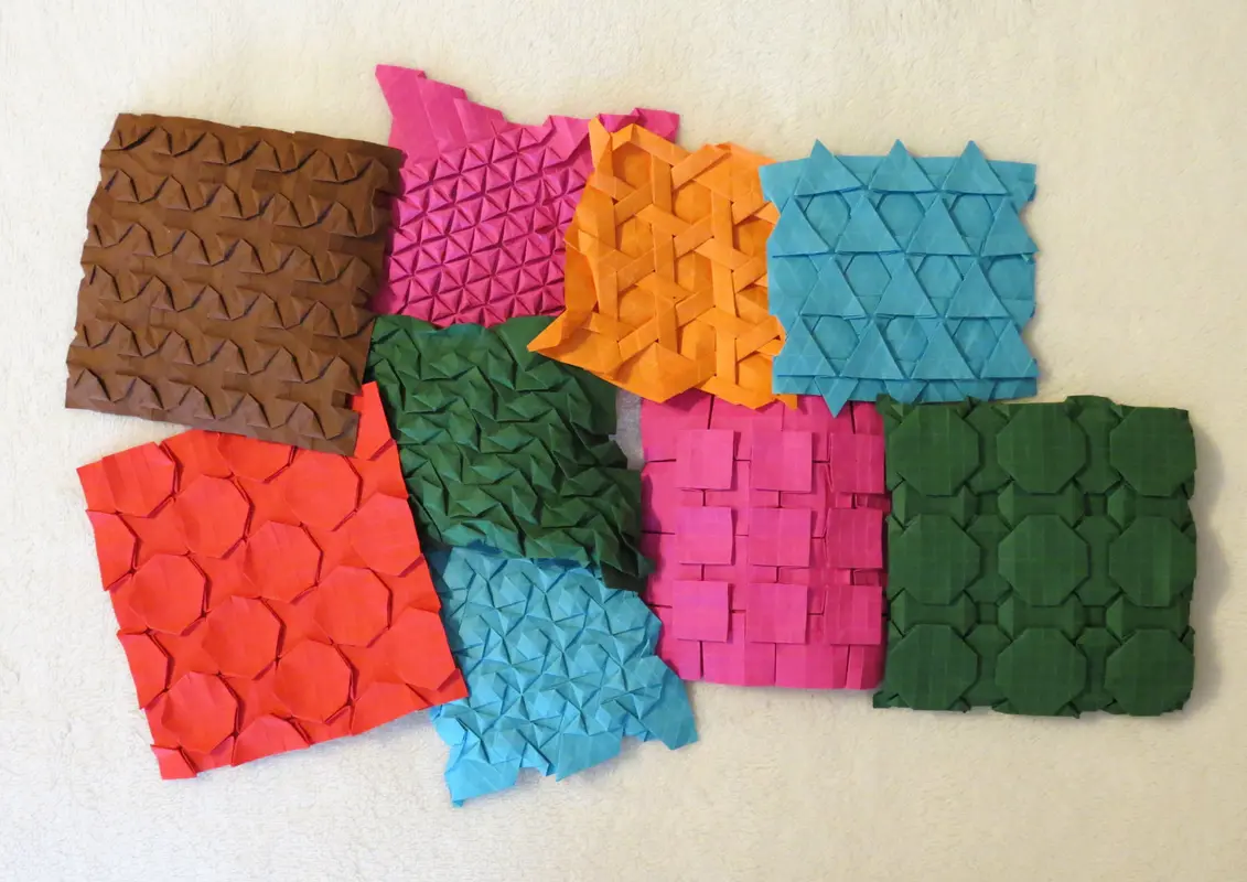 An intricate geometric pattern featuring high-precision folds across a continuous grid of folded paper.