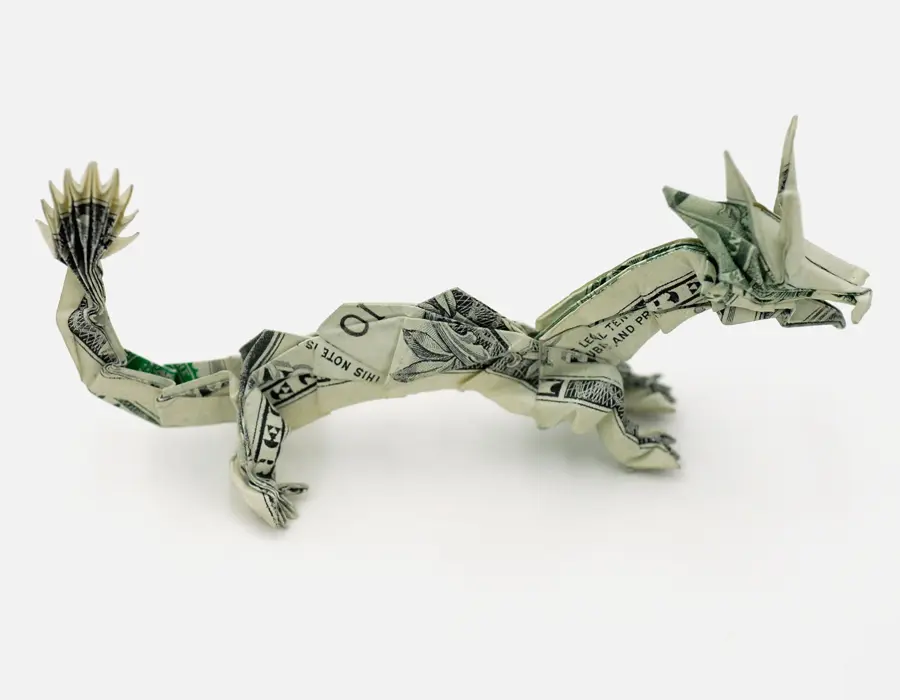 A pair of hands carefully creasing a banknote without using any scissors or adhesive glue.