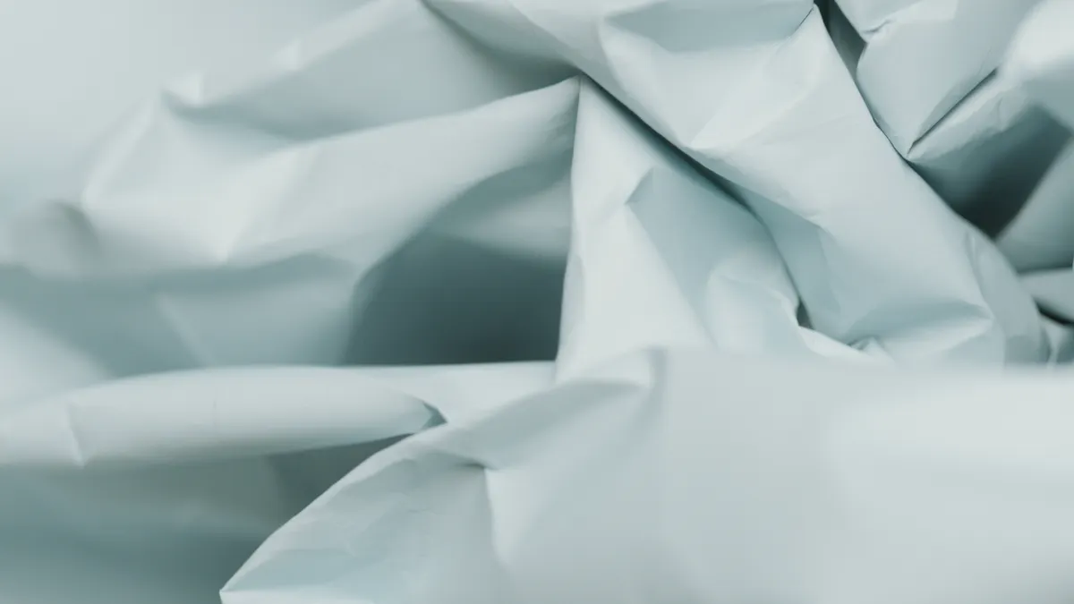 Close-up of thin kami paper holding a sharp crease for folding.