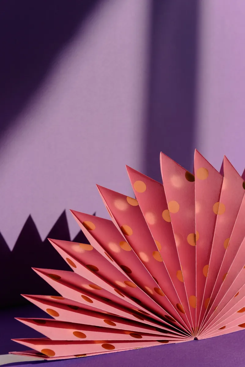 A handmade kirigami pop-up greeting card displaying intricate folded and cut paper architecture.