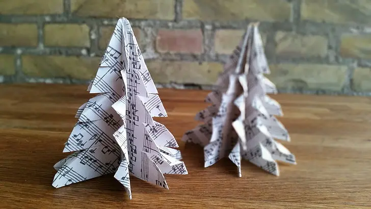 A detailed close up of a single handmade paper crane resting on a textured surface.