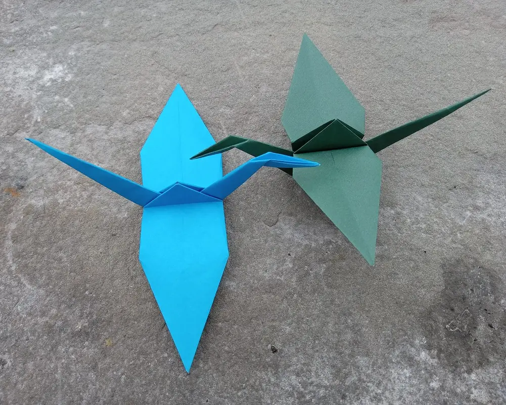 Folded paper models laid out next to a comparison guide for first time folders
