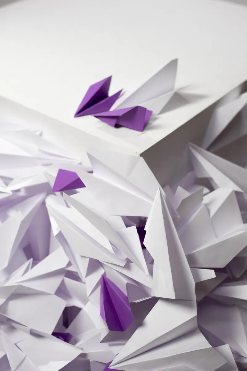 A damp paper model resting on a table to dry and set its sculpted shape.