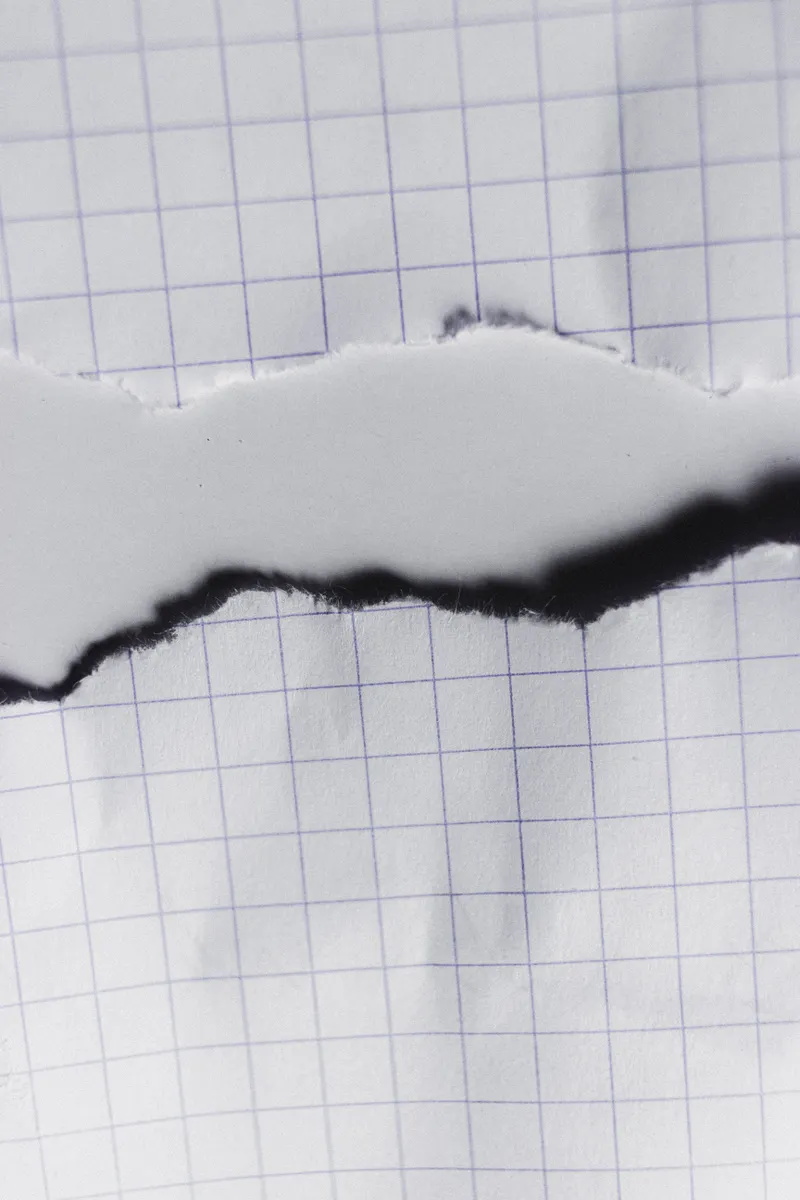 Close up of a tear in thick paper caused by using excessive water during folding.