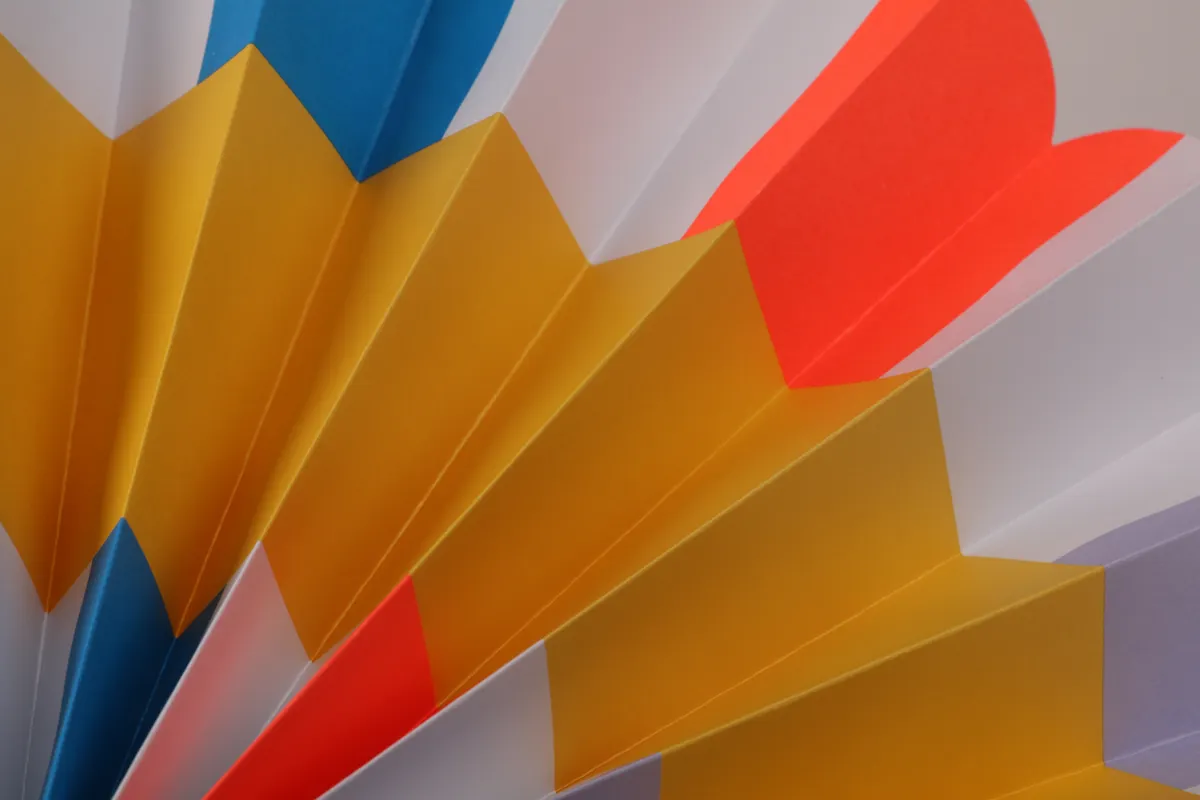 Close-up of precise paper folds on a modular origami unit used as a template.