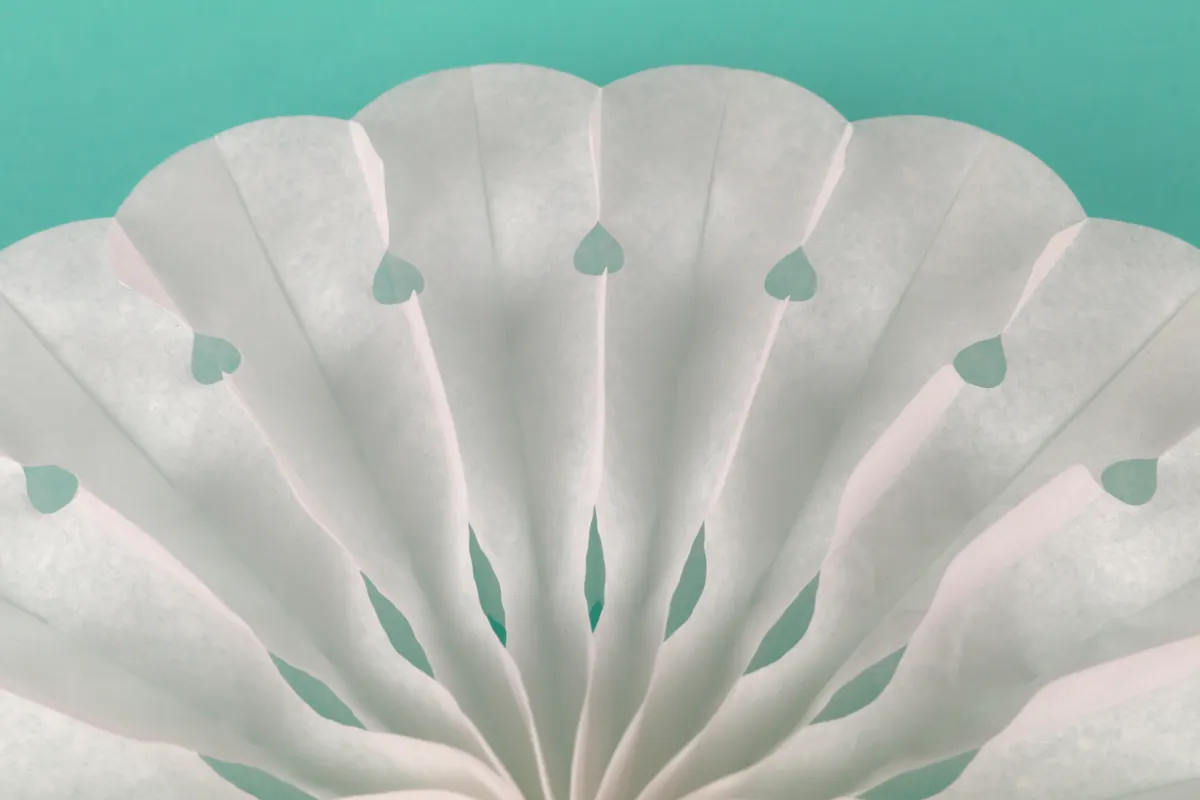 A simple paper architecture model being test folded to ensure it opens and closes flat correctly.