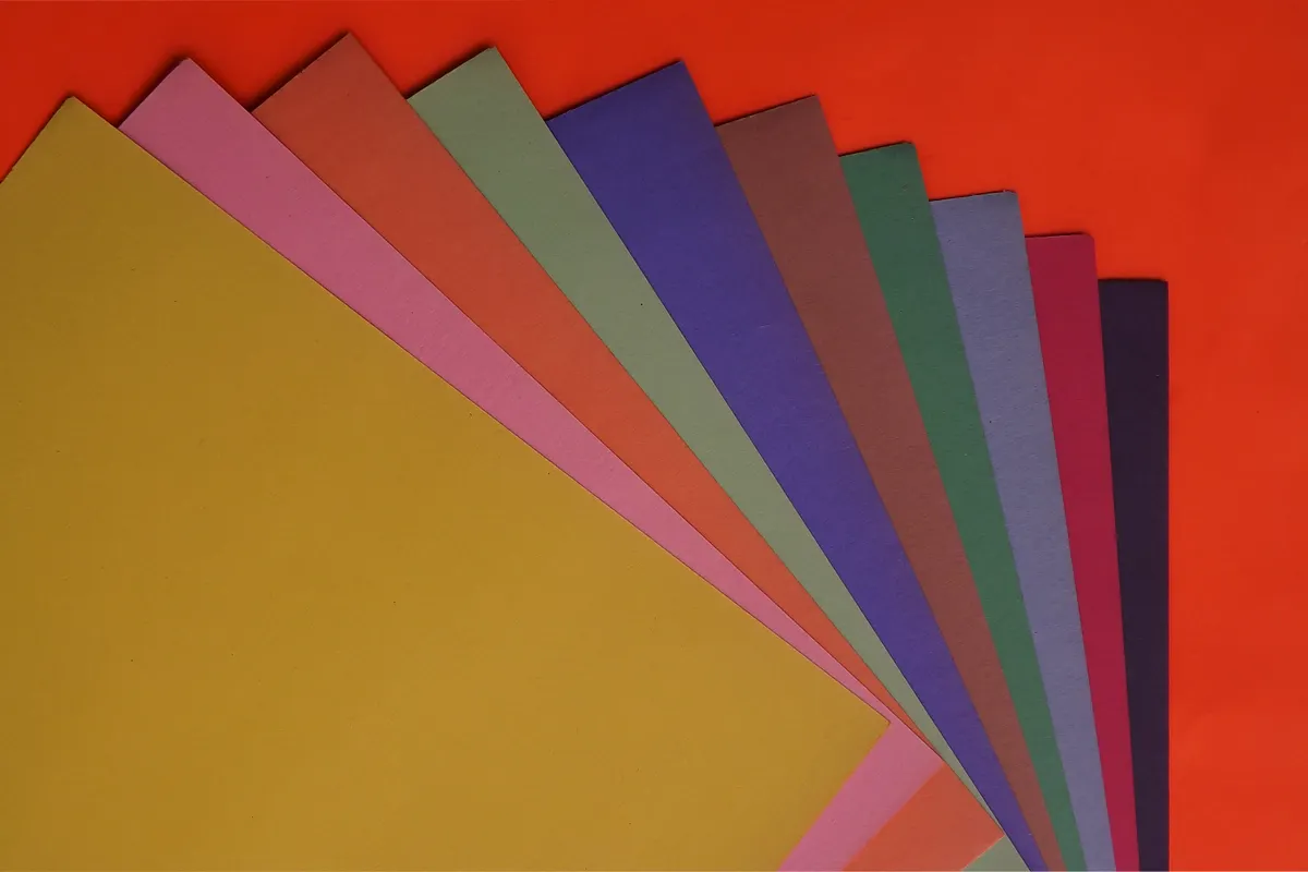 Assorted solid color origami papers laid out for beginners.